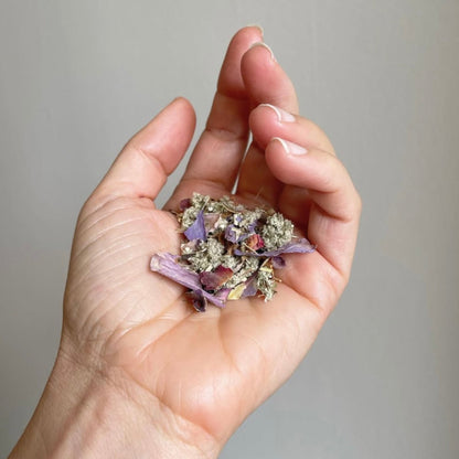 The herbal blend of Dream Tea held in the palm of a hand. 