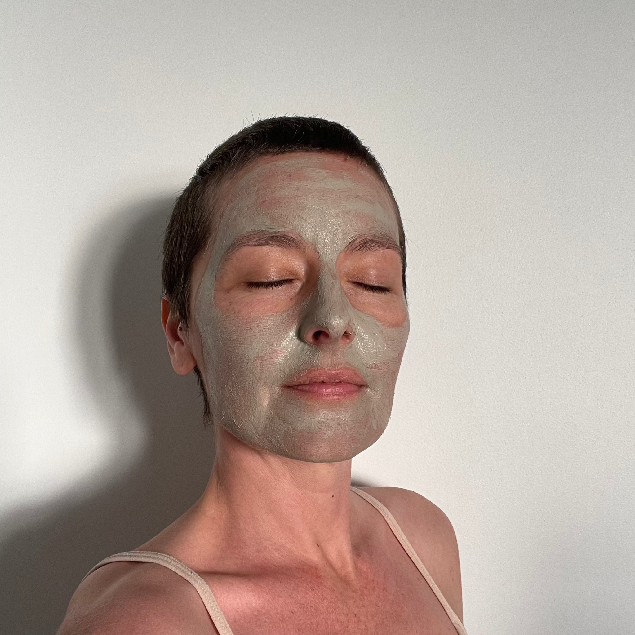 Green clay mask on woman&