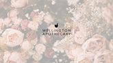 The black Wellington Apothecary logo on a faded background of roses. 