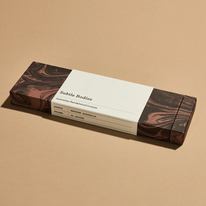 A dark brown box of Australian Sandalwood Incense on beige background. 