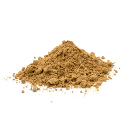 A small pile of sandalwood powder on a white surface. 