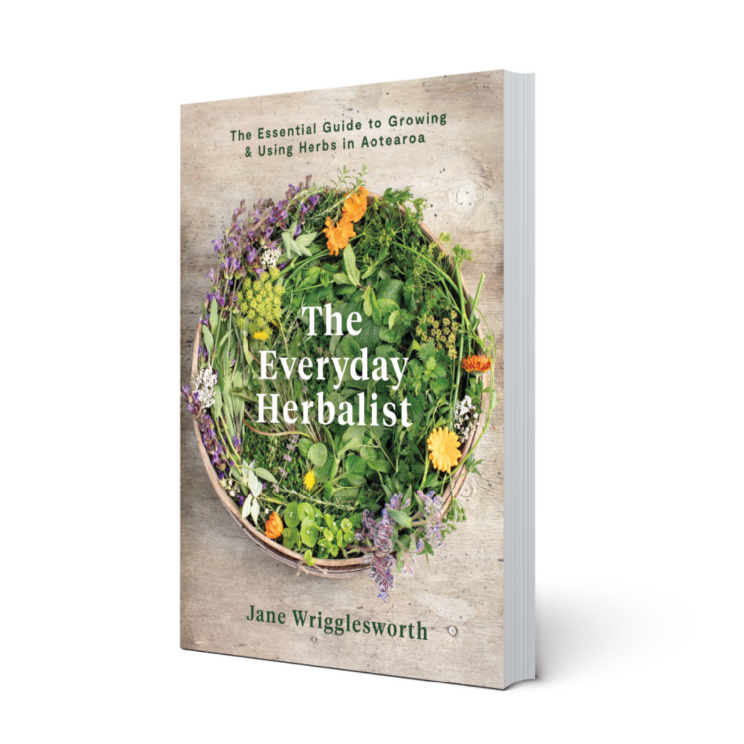 The book cover of The Everyday Herbalist with an image of a basket filled with gathered wild and garden herbs. 