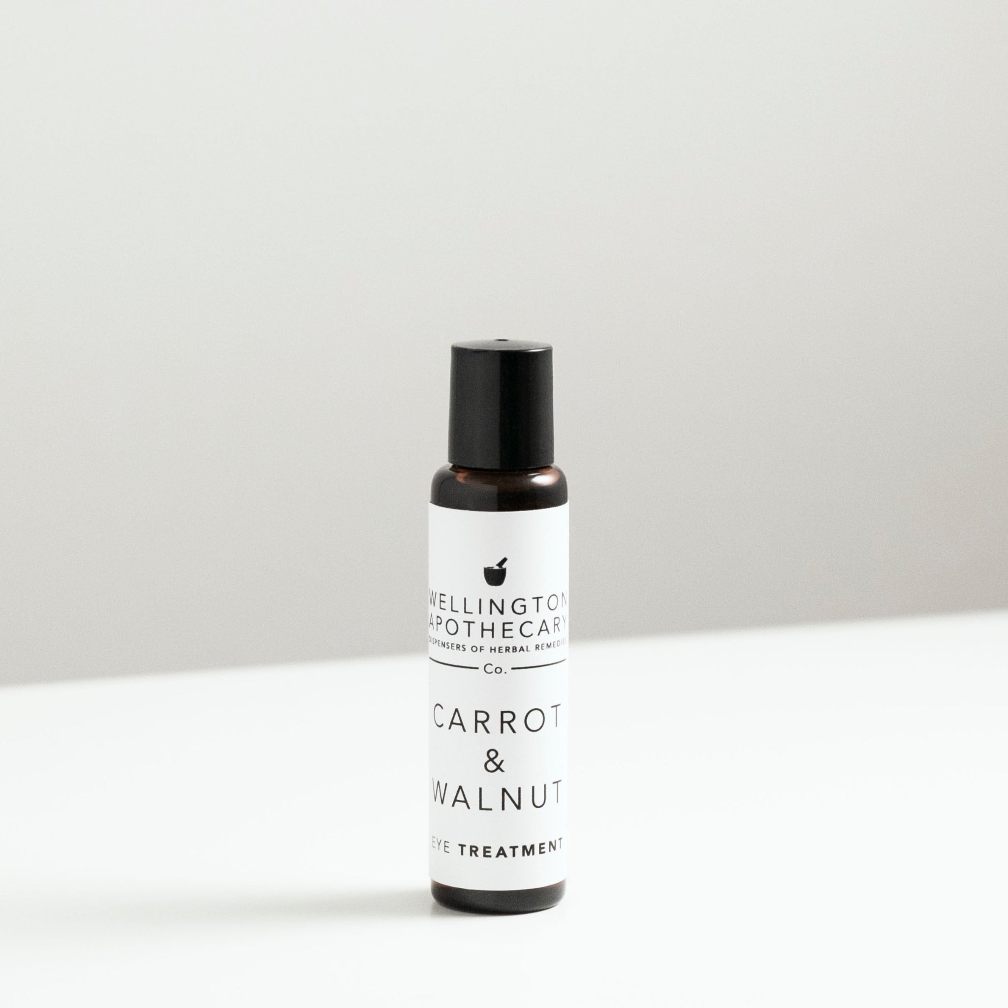 A narrow amber glass bottle with carrot and walnut eye treatment oil blend. 